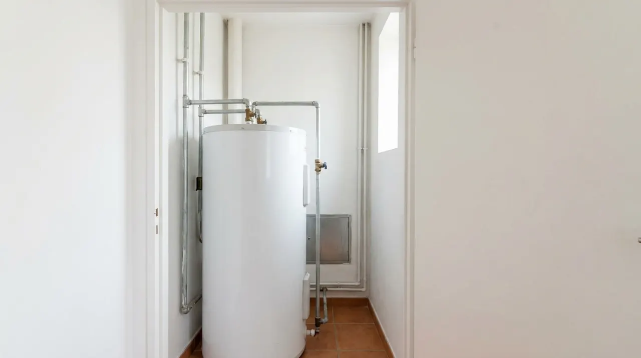 Illustrative image: a tank water heater standing in a home utility closet